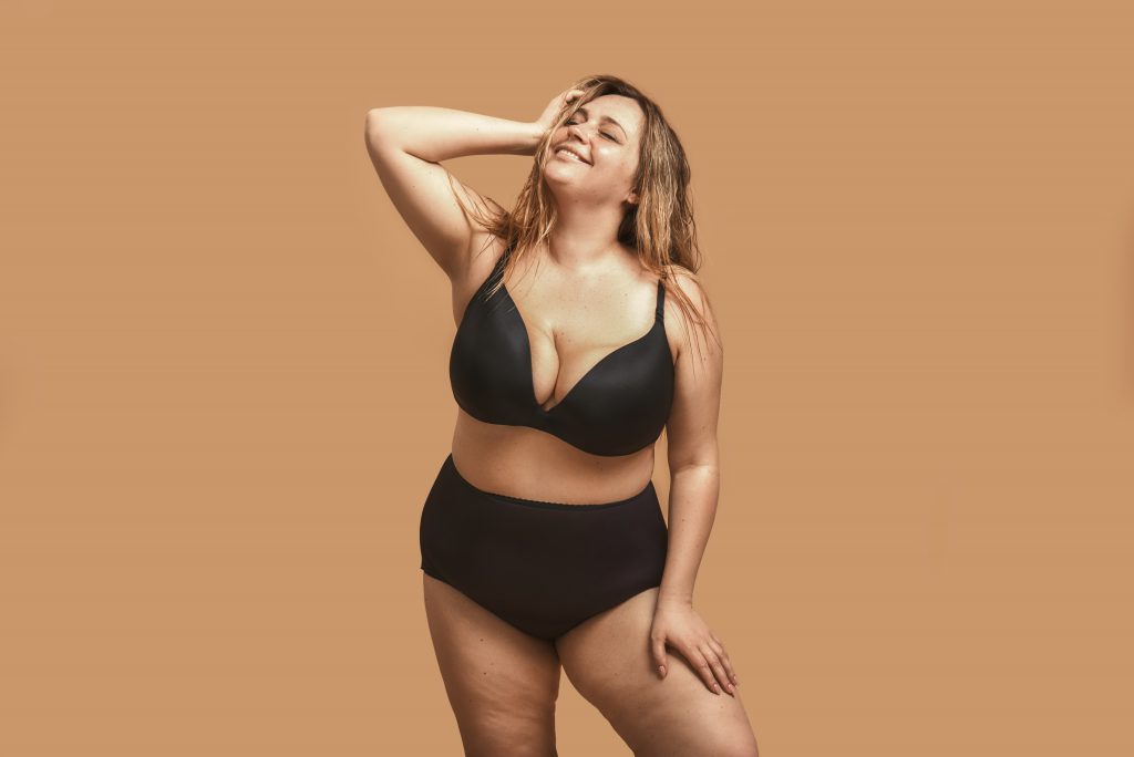 Beautiful and happy plus size woman in plus size lingerie