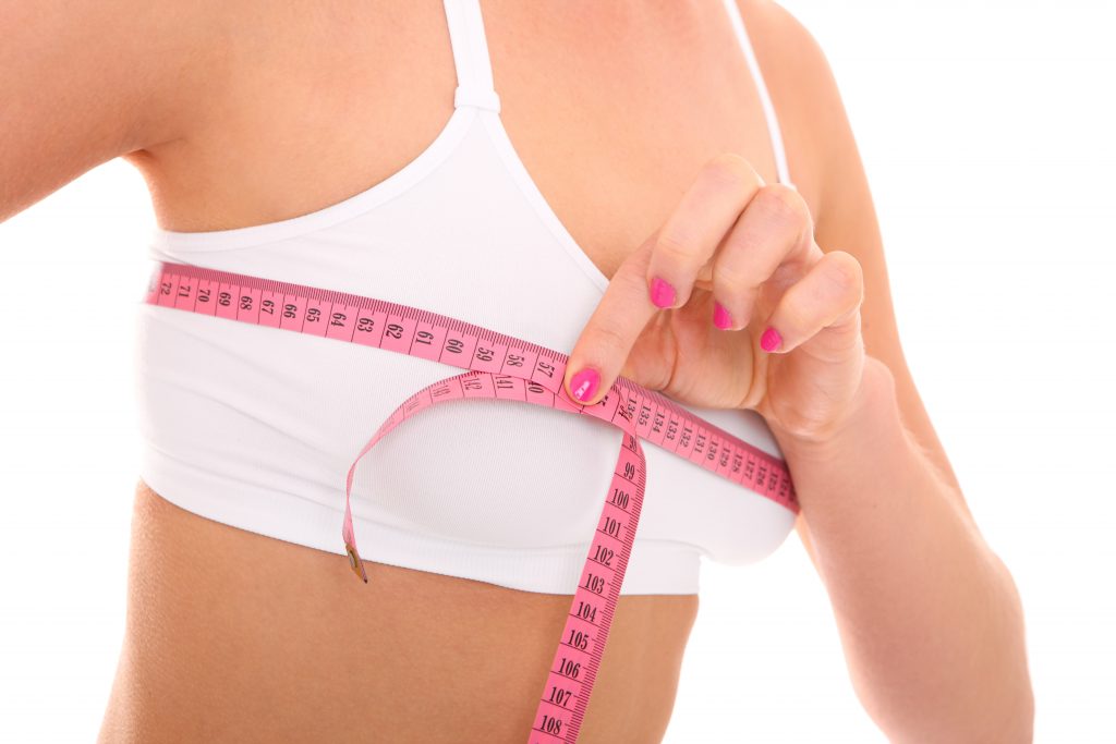 A picture of a woman checking her breast measurement